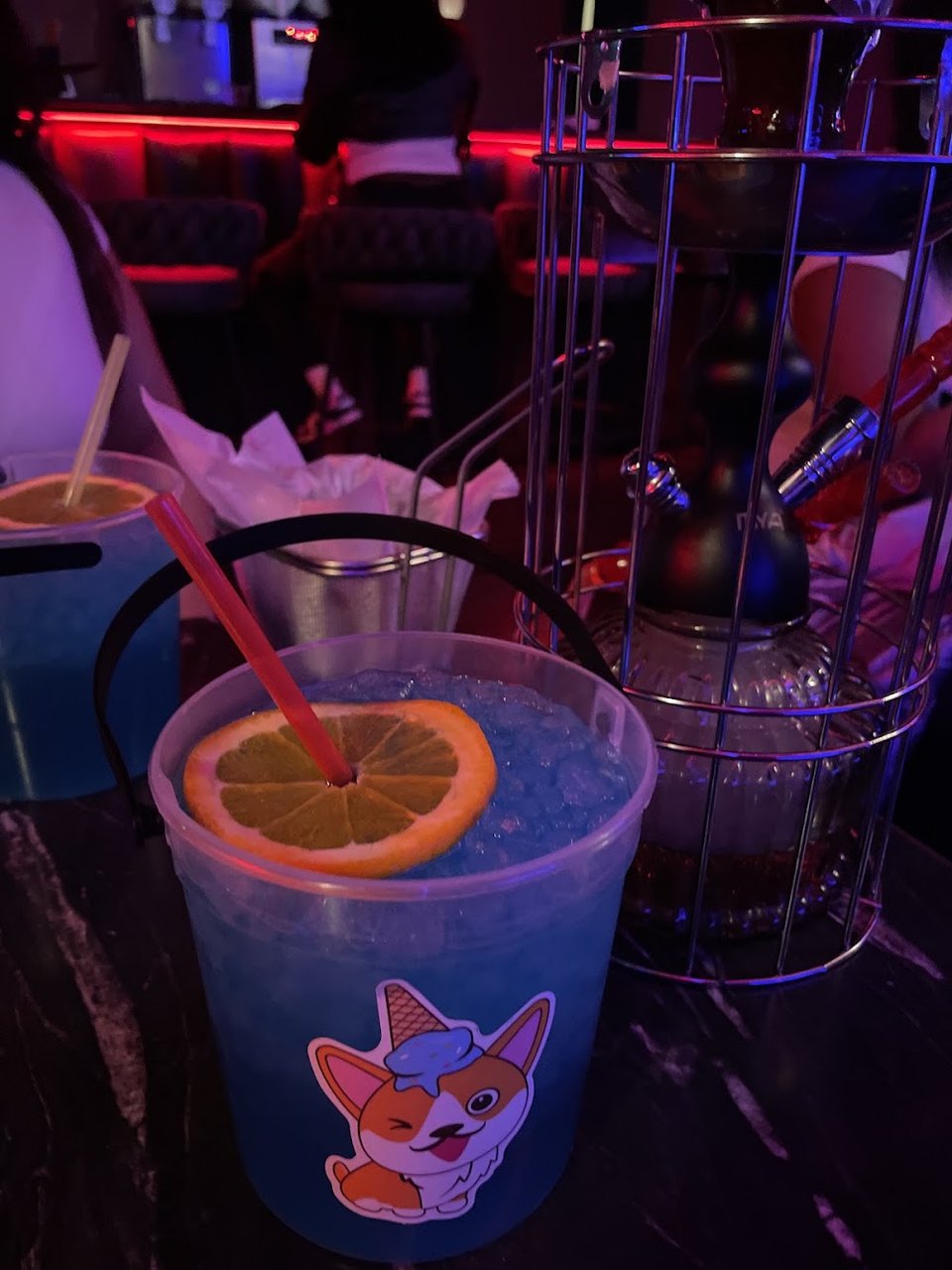 Cocktail menu beside a dimly lit table.